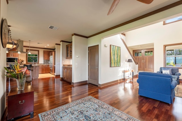 living room featuring dark hardwood / wood-style floors, sink, and crown molding