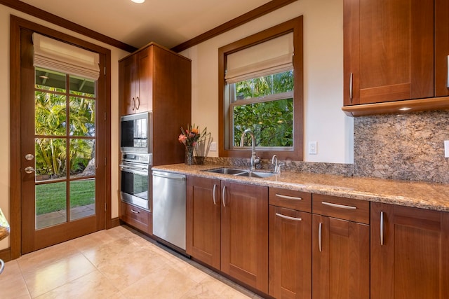 kitchen featuring light stone countertops, appliances with stainless steel finishes, decorative backsplash, crown molding, and sink