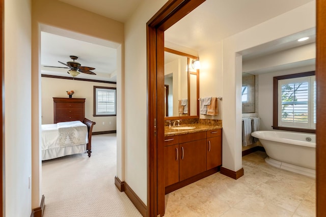 bathroom with ceiling fan, a bathtub, and vanity