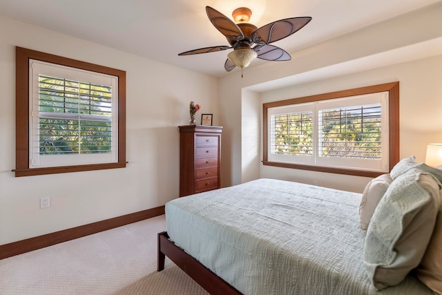 bedroom with multiple windows, ceiling fan, and carpet