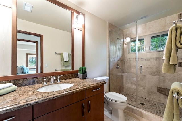 bathroom with tile patterned floors, vanity, toilet, and a shower with door