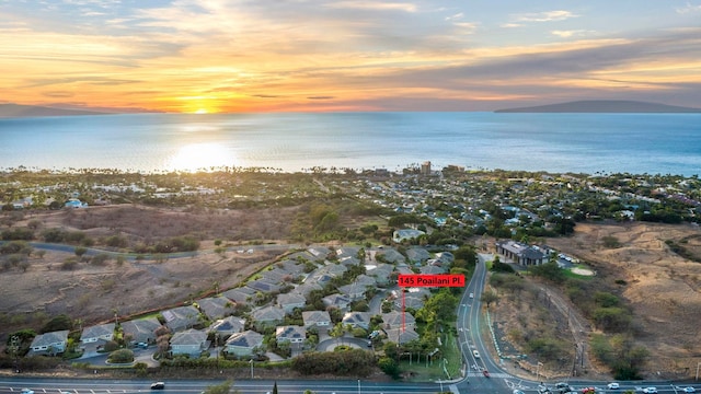 aerial view at dusk featuring a water view