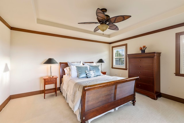 carpeted bedroom with a raised ceiling, ceiling fan, and crown molding