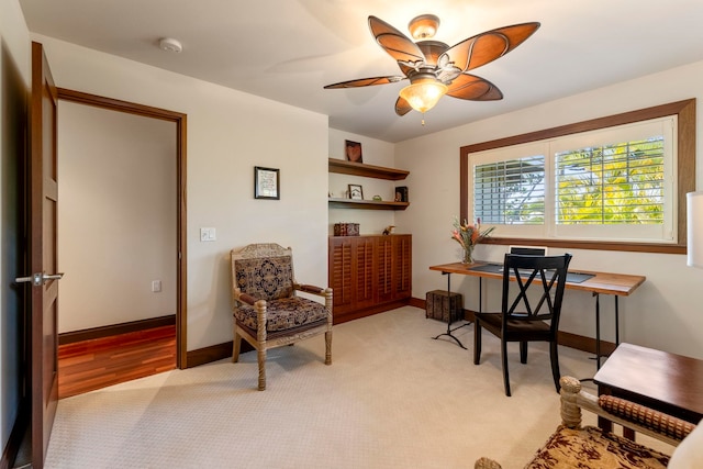 carpeted office space with ceiling fan