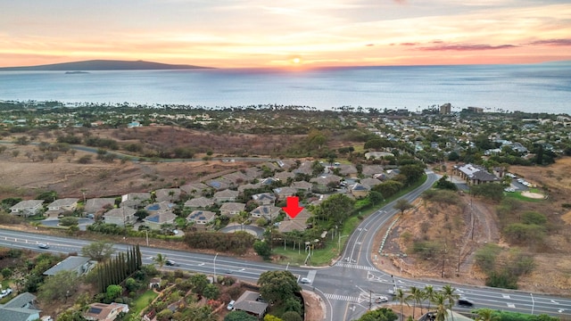 aerial view at dusk featuring a water view