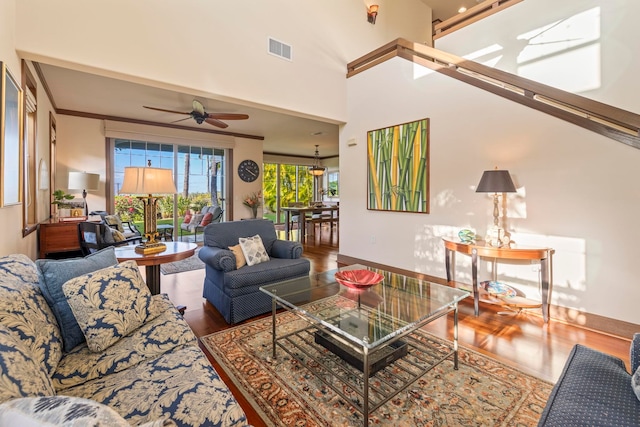 living room with a high ceiling, hardwood / wood-style flooring, and ceiling fan