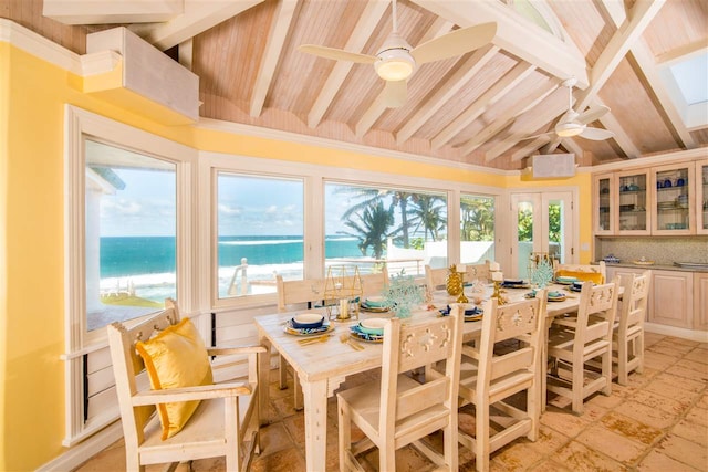 dining room featuring a water view, ceiling fan, and beam ceiling