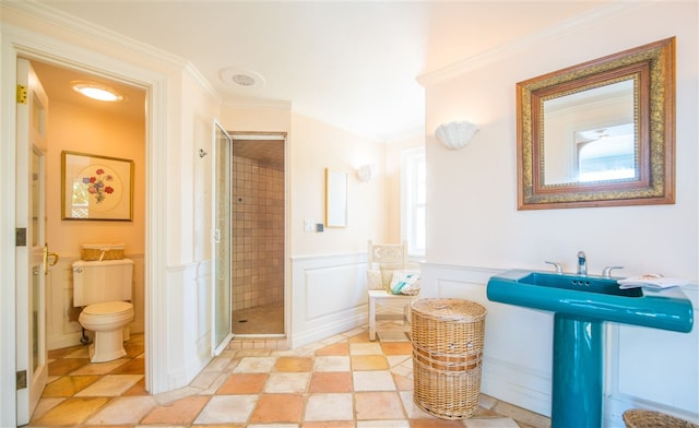 bathroom featuring crown molding, toilet, and walk in shower