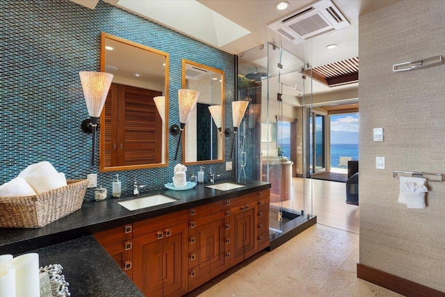 bathroom featuring walk in shower, tile walls, decorative backsplash, a water view, and vanity
