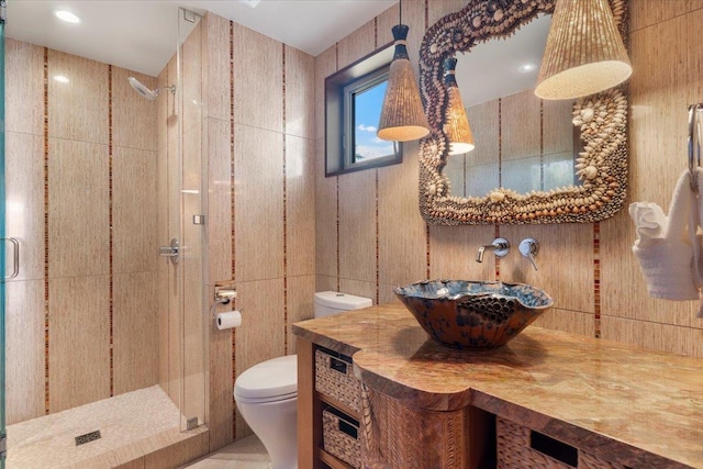 bathroom with sink, toilet, and a shower with door