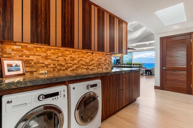 laundry room with light hardwood / wood-style floors and washer and clothes dryer
