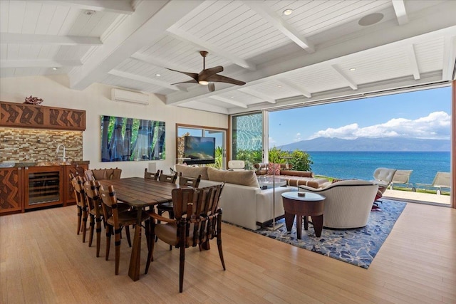 dining room with beverage cooler, vaulted ceiling with beams, bar, light hardwood / wood-style flooring, and a wall mounted air conditioner