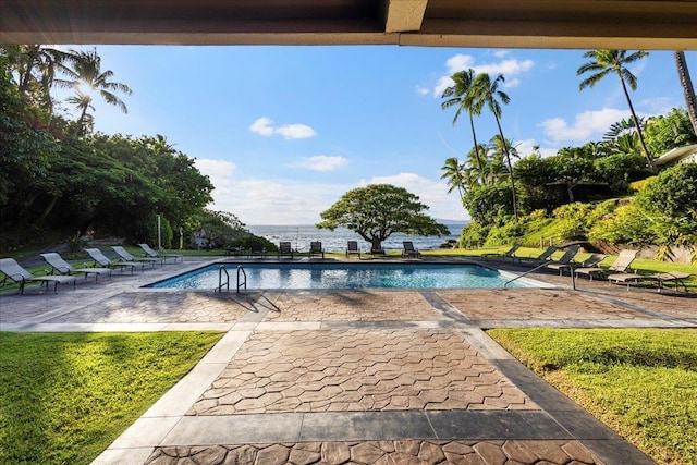view of pool with a patio area and a water view