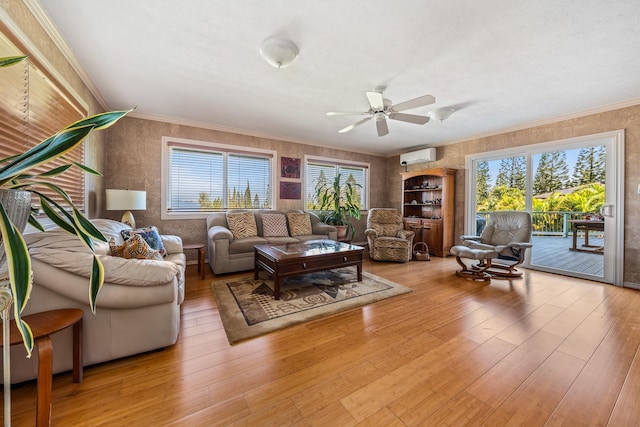 living room with a wall unit AC, ornamental molding, and light wood-type flooring