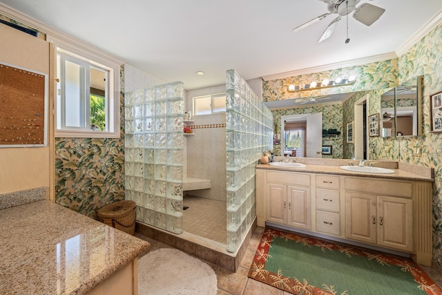 bathroom featuring ceiling fan, tiled shower, vanity, and crown molding