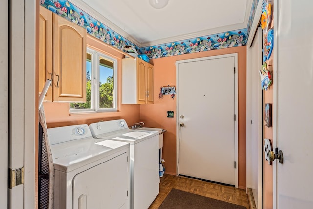 laundry area with parquet flooring, washing machine and clothes dryer, and cabinets