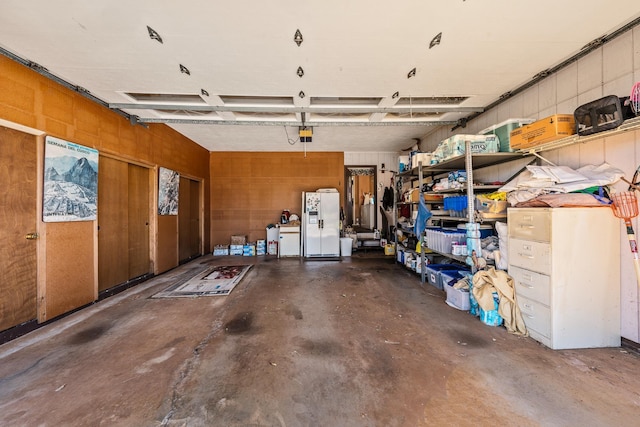 garage featuring white fridge with ice dispenser