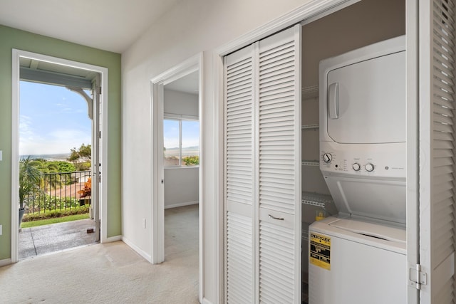 123 Hoowaiwai Loop Unit 1801, Wailuku, HI 96793 - washroom with stacked washing machine and dryer, light colored carpet, and baseboards