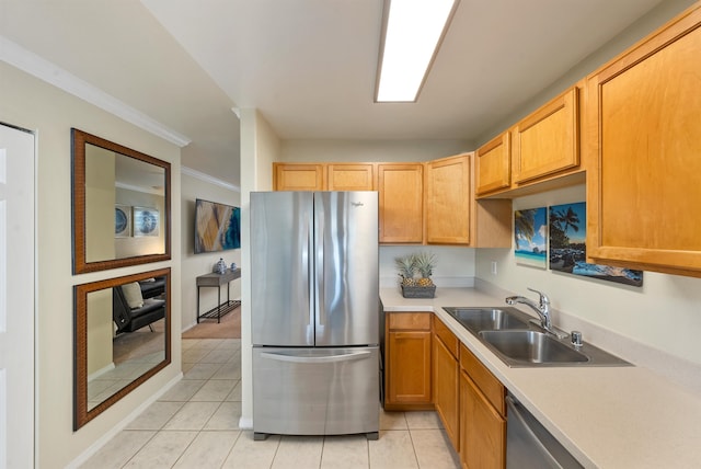 kitchen with sink, stainless steel fridge, ornamental molding, and light tile floors