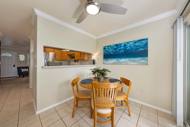 tiled dining space with ornamental molding and ceiling fan