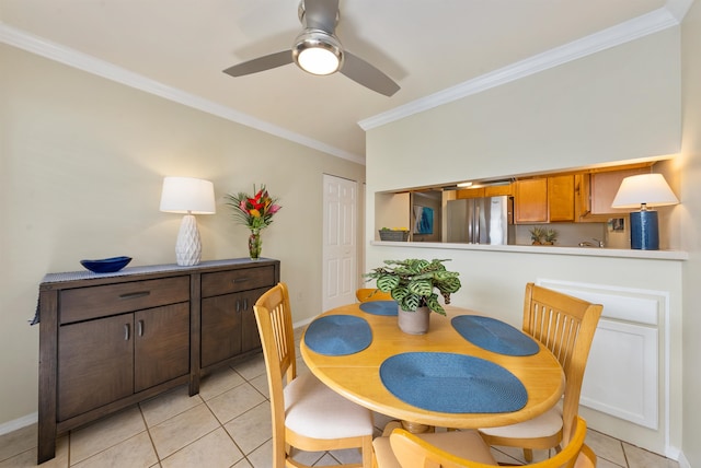 tiled dining room with ceiling fan and crown molding