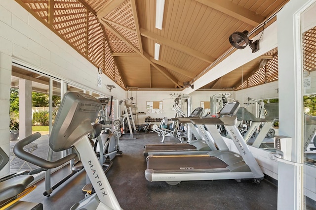 workout area with high vaulted ceiling, concrete floors, and wooden ceiling