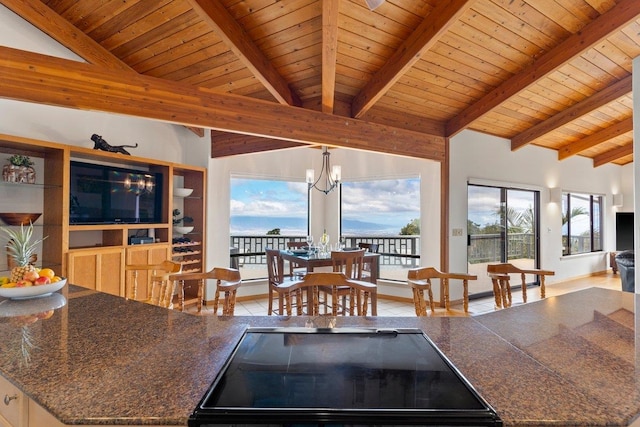 kitchen with decorative light fixtures, a notable chandelier, beam ceiling, high vaulted ceiling, and wooden ceiling