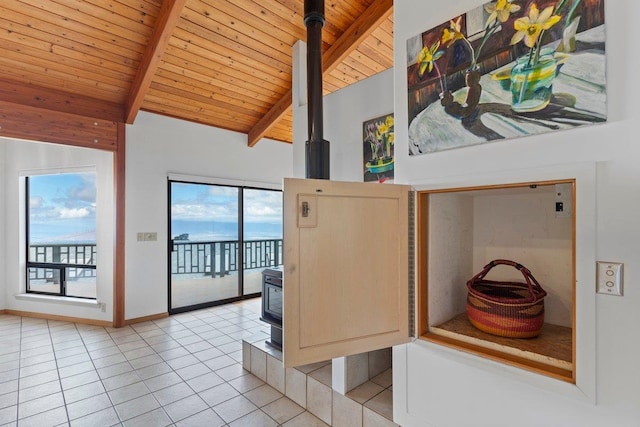 interior space with a water view, wood ceiling, a wood stove, and lofted ceiling with beams