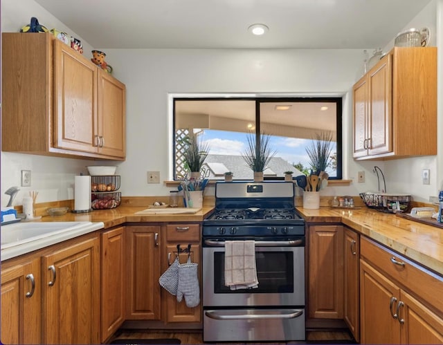 kitchen featuring wooden counters, sink, and gas stove