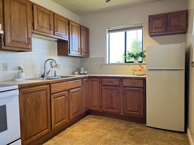 kitchen with decorative backsplash, sink, electric range oven, and white fridge