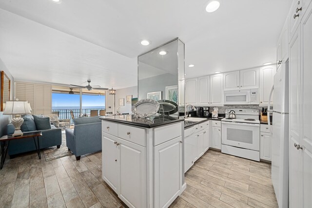 kitchen featuring white appliances, dark countertops, a sink, and decorative backsplash