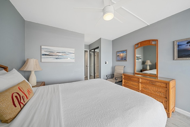 bedroom featuring a ceiling fan, baseboards, and wood finished floors