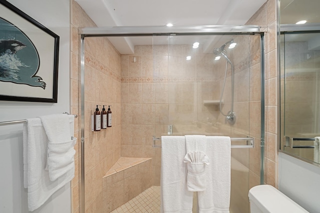 full bathroom featuring a shower stall and toilet