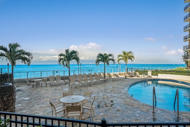 view of pool with a water view and a patio area