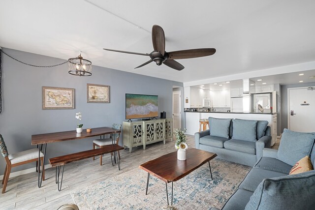 living room featuring recessed lighting and ceiling fan with notable chandelier