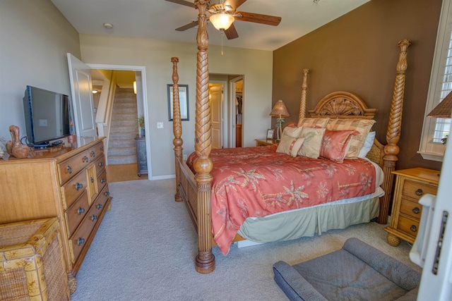 bedroom with ceiling fan, light colored carpet, and connected bathroom