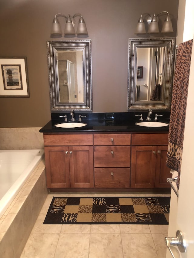 bathroom with tile patterned floors, vanity, and tiled bath