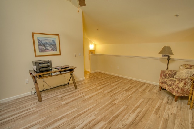 living area with vaulted ceiling, ceiling fan, and light wood-type flooring