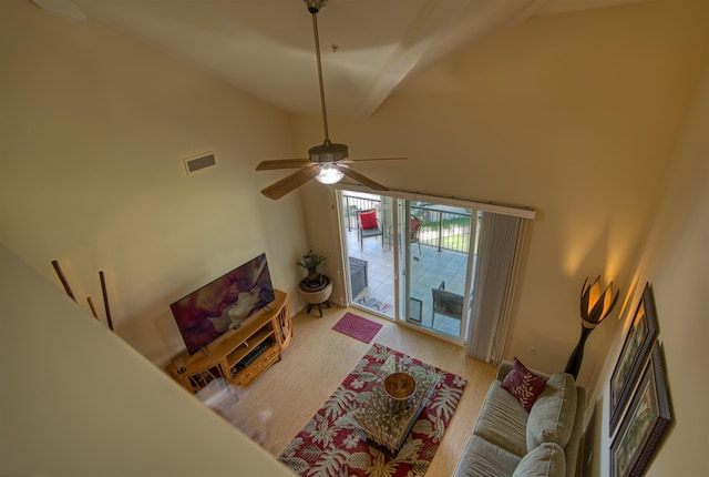 living room with hardwood / wood-style floors, high vaulted ceiling, and ceiling fan