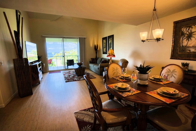 dining space featuring wood-type flooring and a notable chandelier