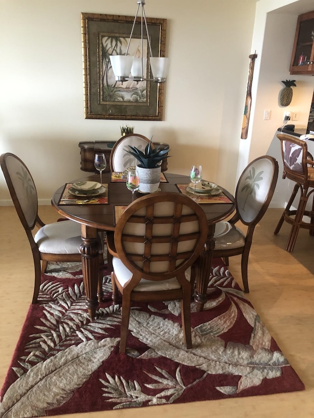 dining area with hardwood / wood-style floors and a notable chandelier