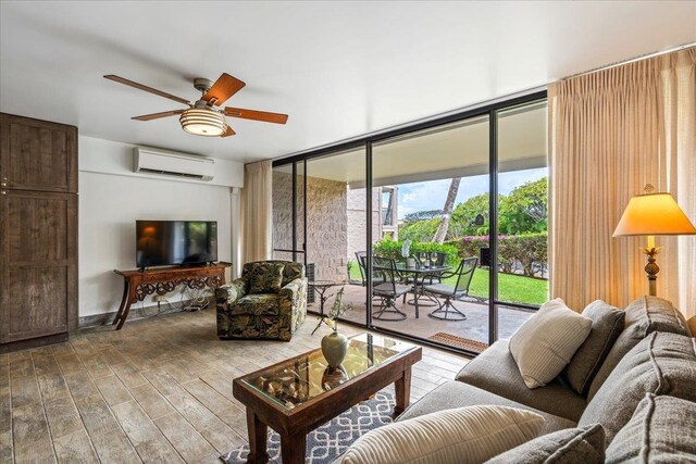 2387 S Kihei Rd Unit C108, Kihei, HI 96753 - living room with a wall mounted AC, wood finished floors, a wall of windows, ceiling fan, and baseboards