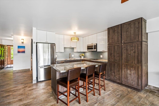 2387 S Kihei Rd Unit C108, Kihei, HI 96753 - kitchen with stainless steel appliances, dark wood finished floors, dark brown cabinetry, and a center island