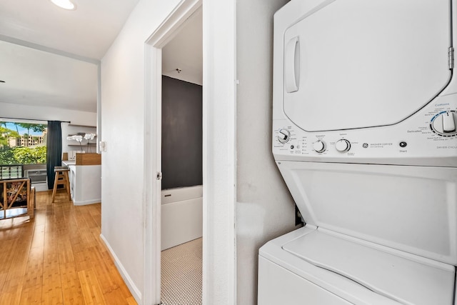 15 Kulanihakoi St Unit 3E, Kihei, HI 96753 - clothes washing area with baseboards, light wood finished floors, laundry area, and stacked washer / drying machine