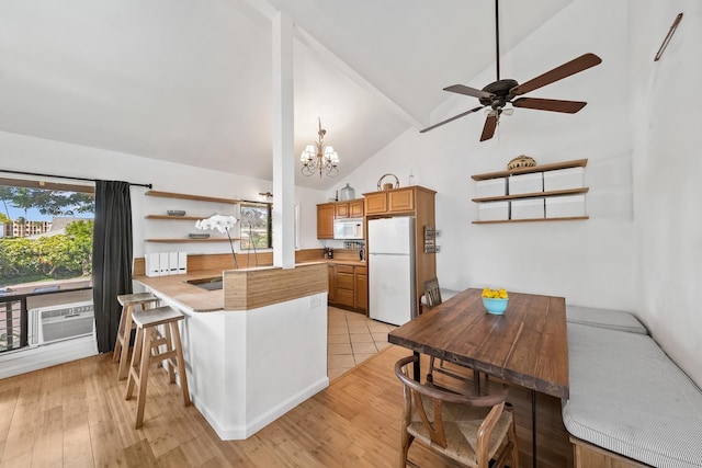 15 Kulanihakoi St Unit 3E, Kihei, HI 96753 - kitchen with white appliances, ceiling fan with notable chandelier, a peninsula, high vaulted ceiling, and brown cabinets