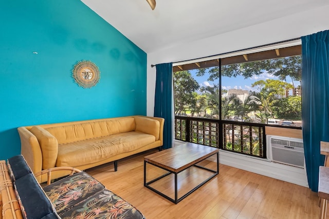 15 Kulanihakoi St Unit 3E, Kihei, HI 96753 - living room featuring an AC wall unit, wood finished floors, and vaulted ceiling