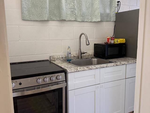 471 Liholiho St Unit 25, Wailuku, HI 96793 - kitchen featuring electric range, white cabinets, black microwave, and decorative backsplash