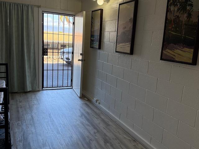 471 Liholiho St Unit 25, Wailuku, HI 96793 - doorway to outside featuring wood finished floors and concrete block wall