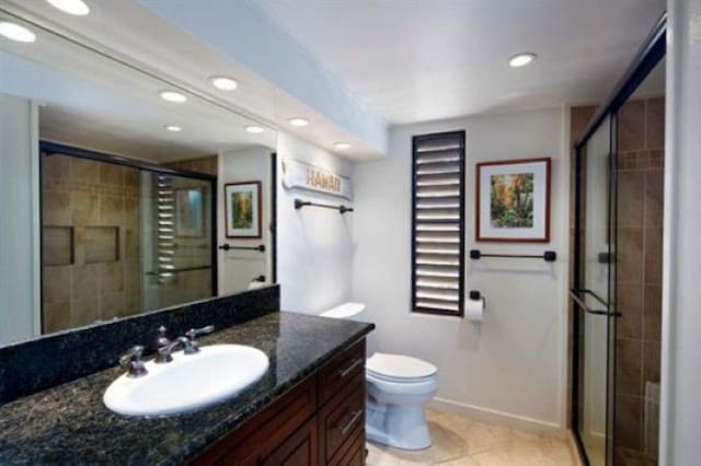 bathroom featuring vanity, a shower with shower door, tile patterned floors, and toilet