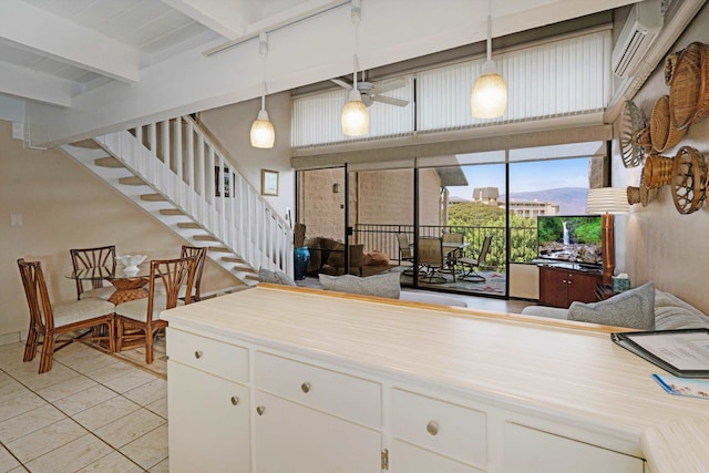 kitchen with beam ceiling, ceiling fan, white cabinetry, hanging light fixtures, and light tile patterned floors